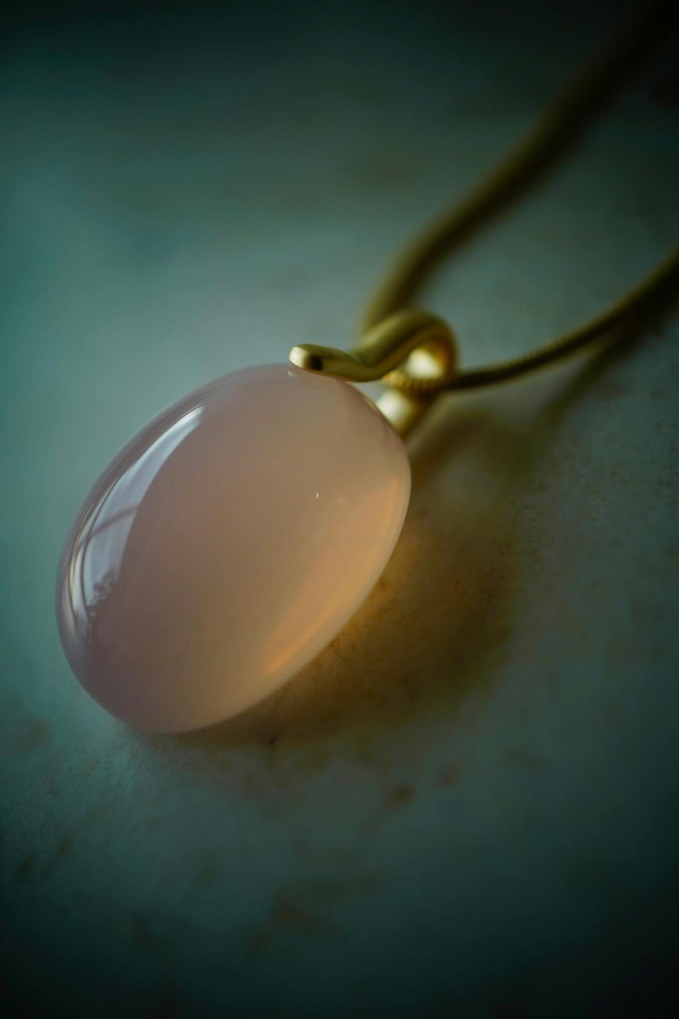 Yukimoto's limited edition Alaskan rose quartz pendant featuring a delicate oval stone on a gold chain.