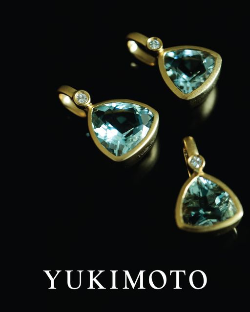 Elegant gold pendants with blue gemstones by Yukimoto, showcasing luxury and craftsmanship in fine jewelry.