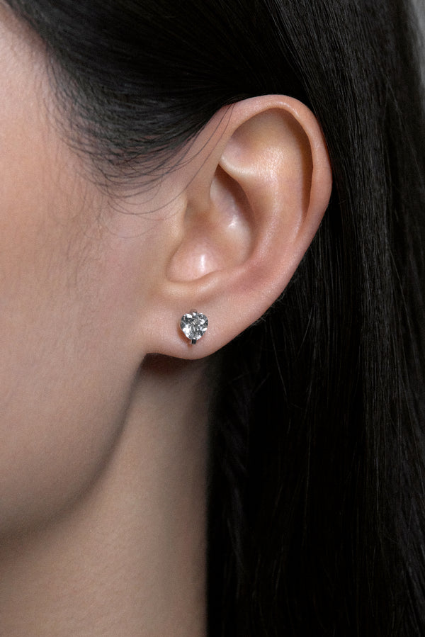 Close-up of ear featuring white noise pulse studs with hand-cut rock crystals in sterling silver.