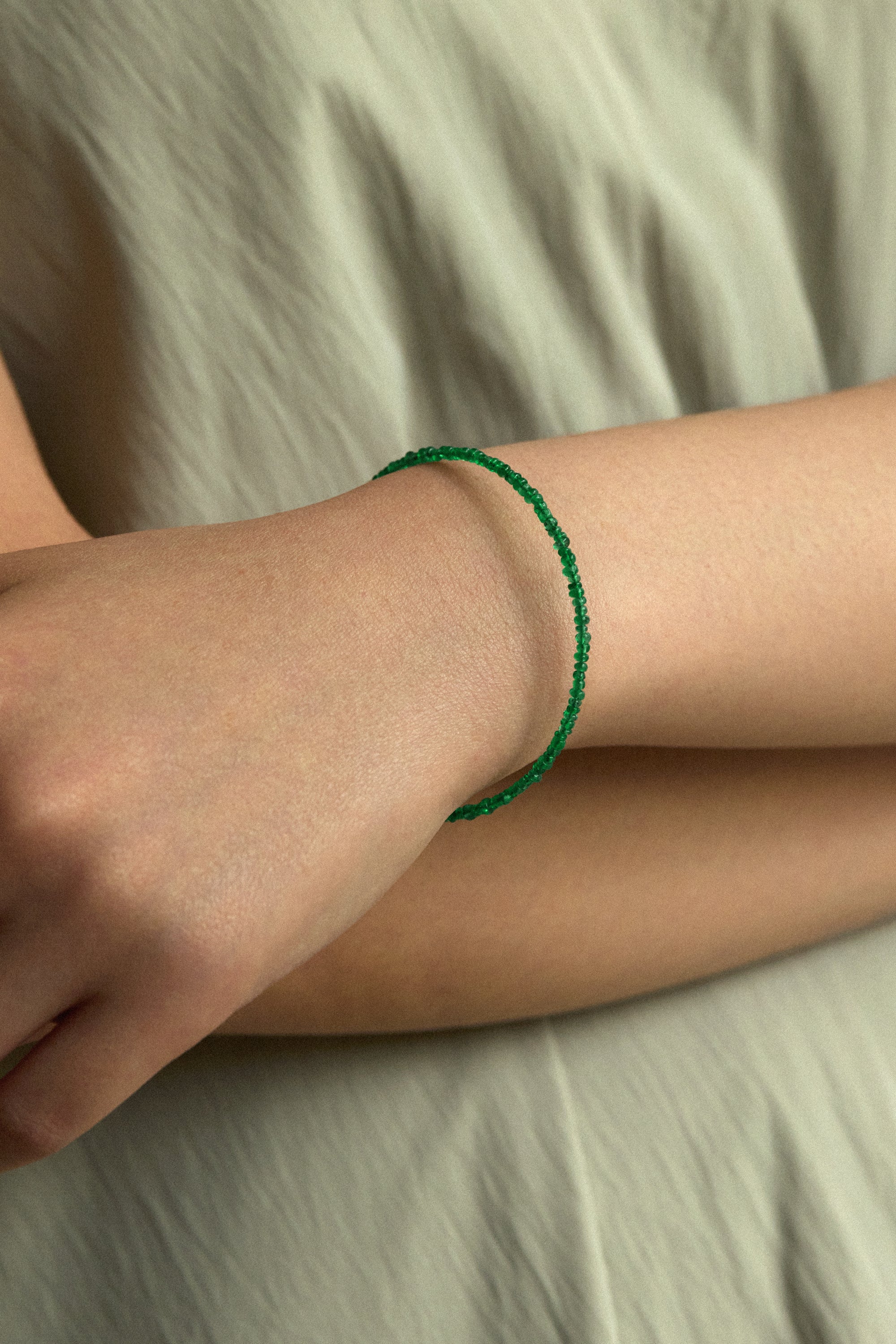 Muzo Emerald Bracelet worn on a woman's wrist, featuring vibrant green Colombian emerald beads.