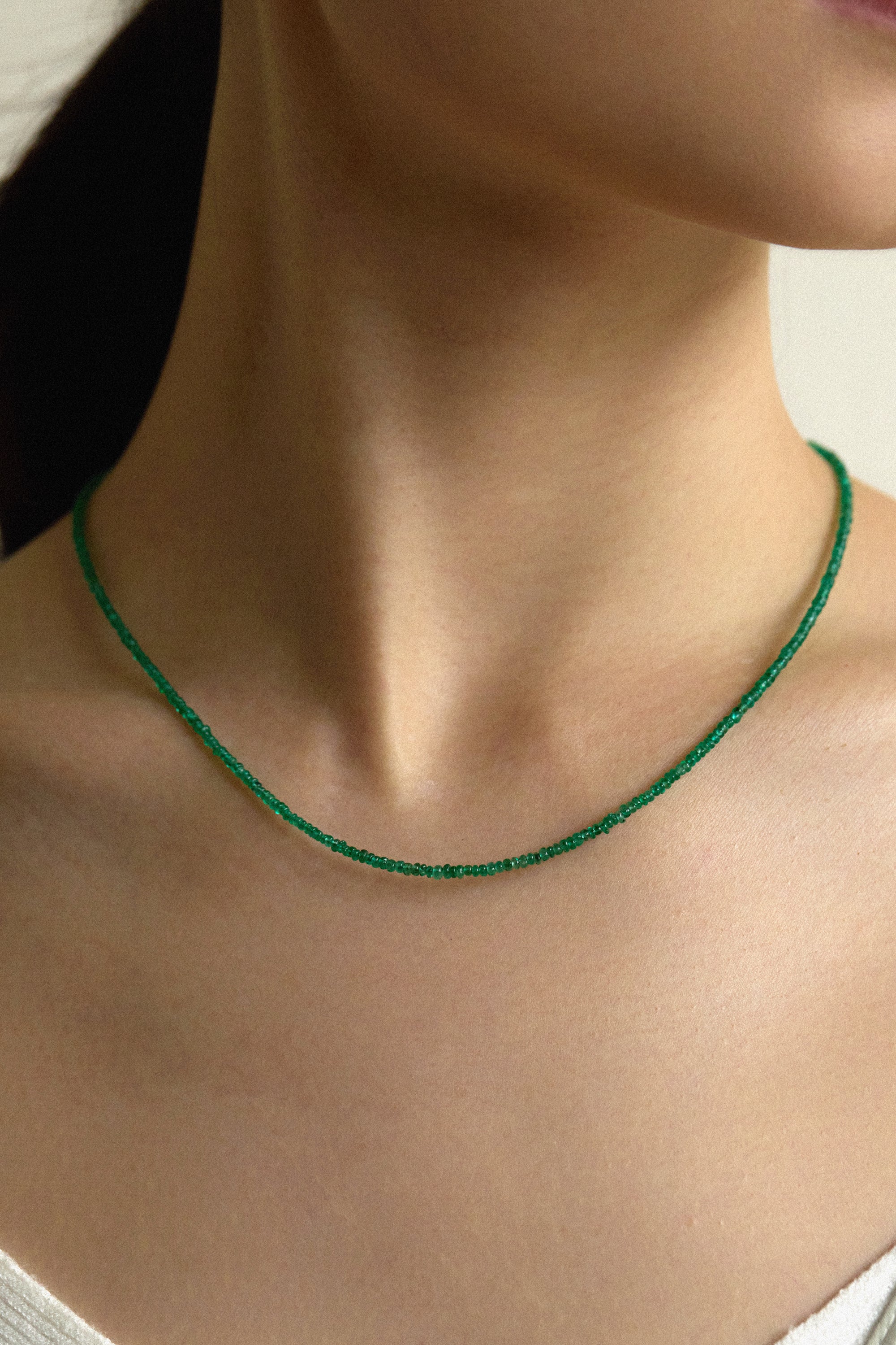 Muzo Emerald Necklace showcasing vibrant Colombian emerald beads worn elegantly around the neck.