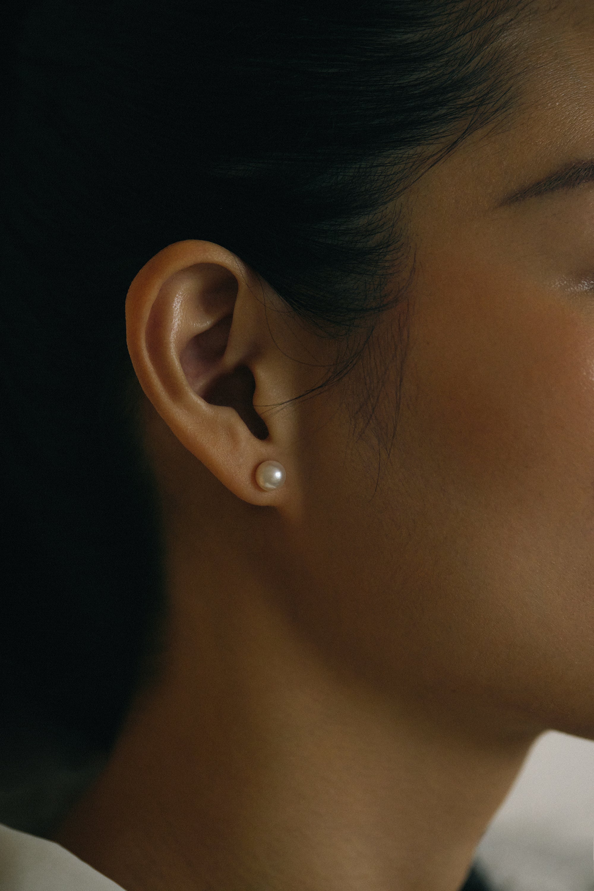 Elegant Akoya pearl ear studs showcased on a model's ear, highlighting their premium quality and lustrous shine.