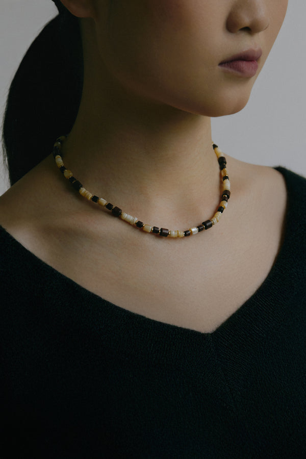 Close-up of Red Sandalwood necklace with luminous seashell charm