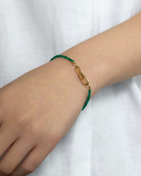 Muzo Emerald Bracelet worn on a wrist, showcasing the vibrant green Colombian emerald beads and gold clasp.