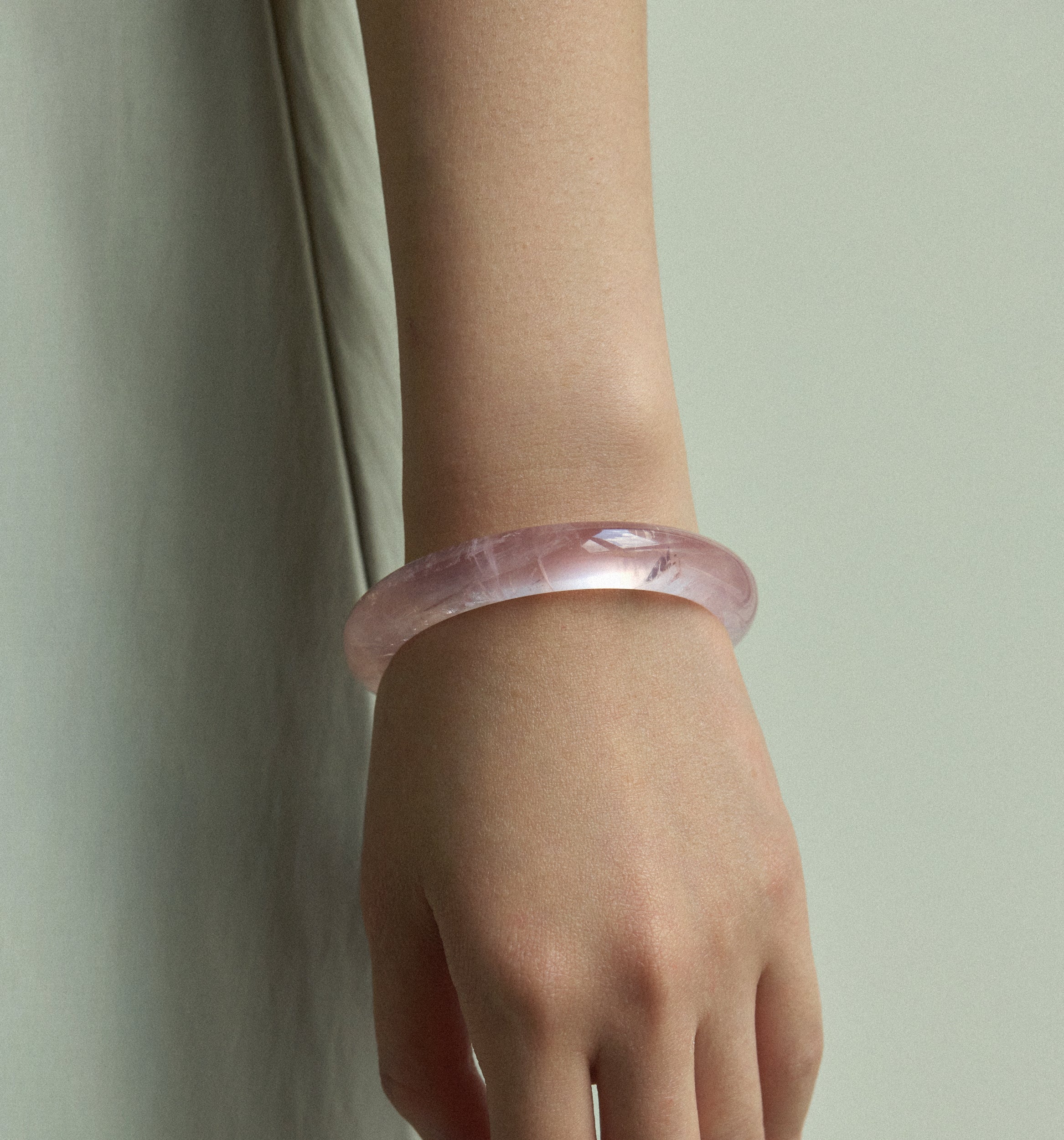 Elegant Madagascar Rose Quartz Bangle worn on wrist, showcasing its soft pink hue and modern design.