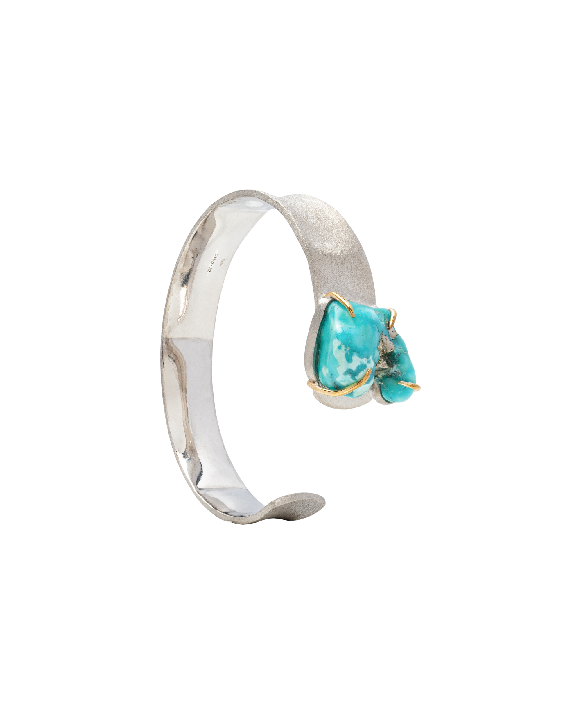 Handcrafted raw turquoise bangle with unique natural formations in silver setting.