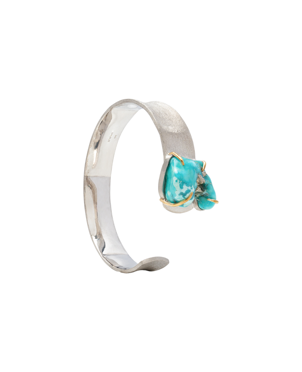 Handcrafted raw turquoise bangle with unique natural formations in silver setting.
