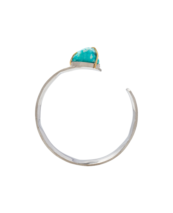Handmade raw turquoise bangle with gold setting, showcasing unique natural formation and irregular shape.