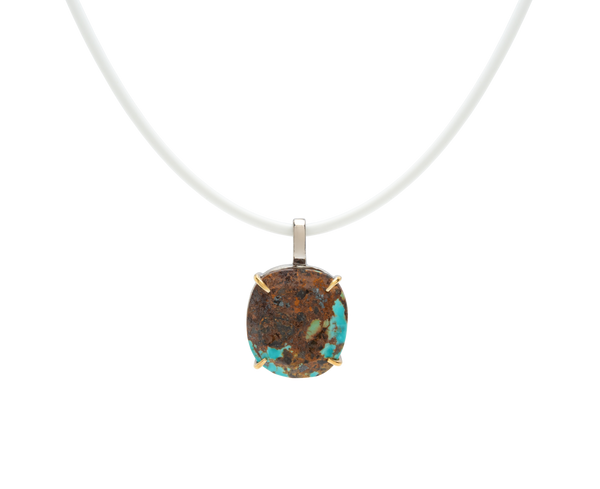 Turquoise handmade pendant necklace with raw turquoise stone on a white cord, showcasing unique natural beauty.