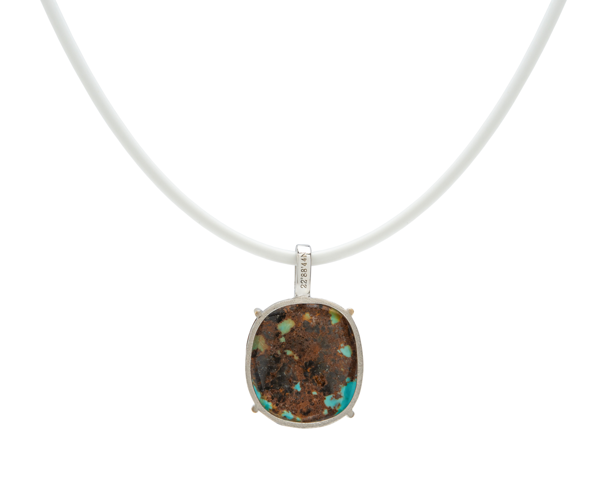 Turquoise handmade pendant necklace featuring a raw turquoise stone on a white cord.